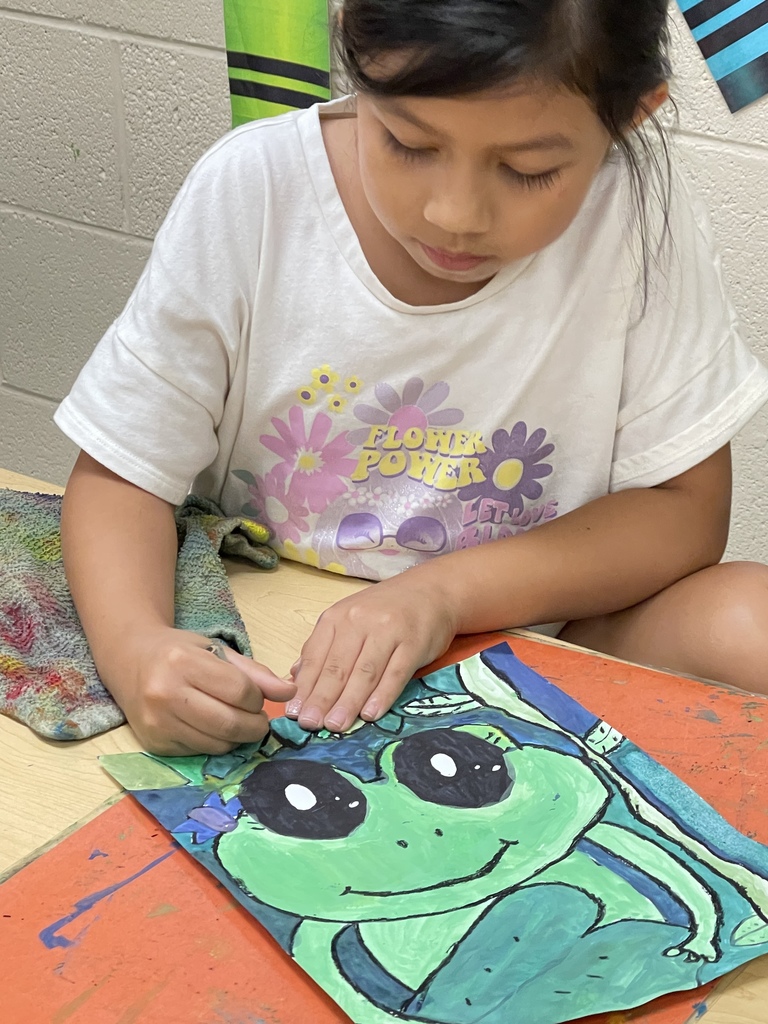 student painting a frog