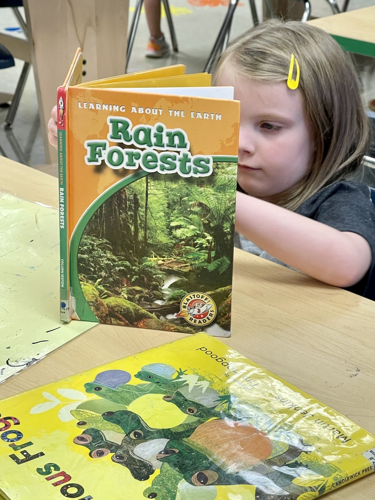 young girl reading about rain forests
